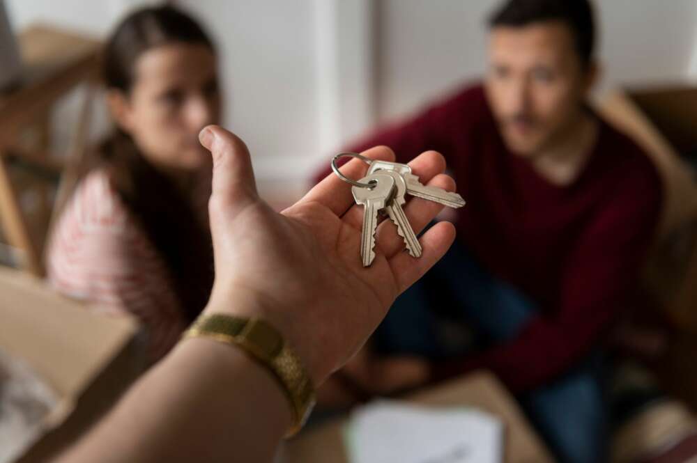 Un propietario entrega unas llaves a una pareja. Foto: Freepik.
