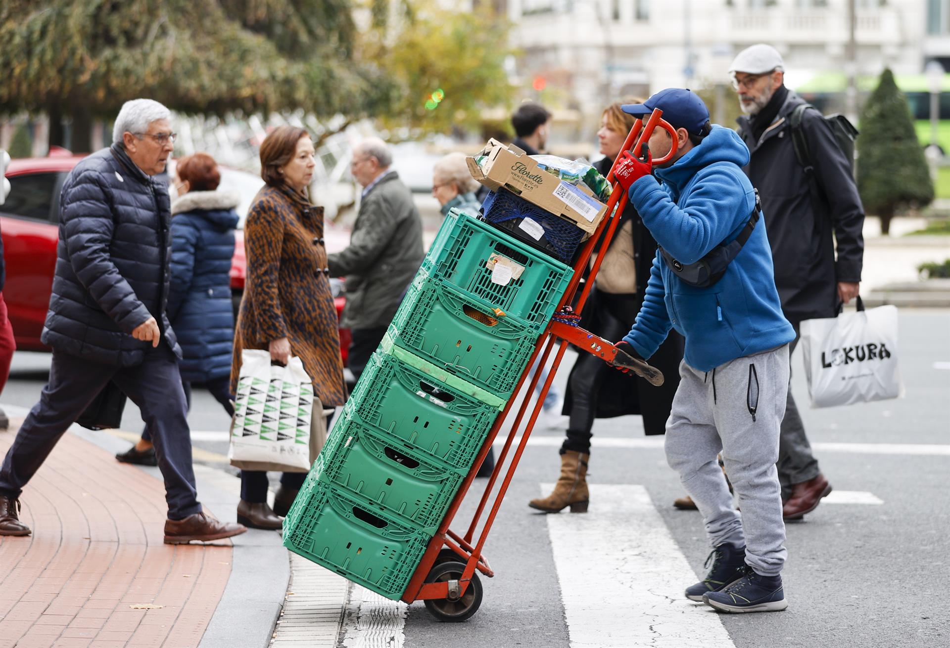 Un trabajador transporta unas cajas. Foto EFE-Luis Tejido
