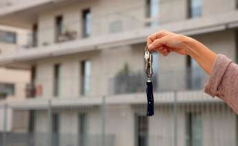 Una mano sostiene unas llaves frente a una casa. Foto: Freepik.