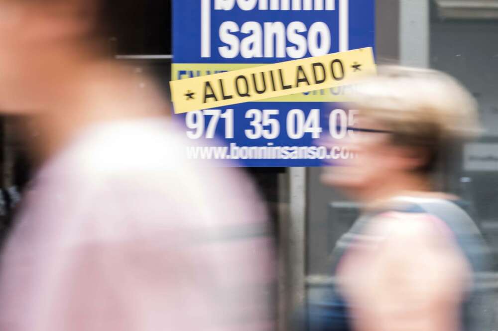 Varias personas caminan frente a un cartel que anuncia el alquiler de una vivienda. Foto: EFE.