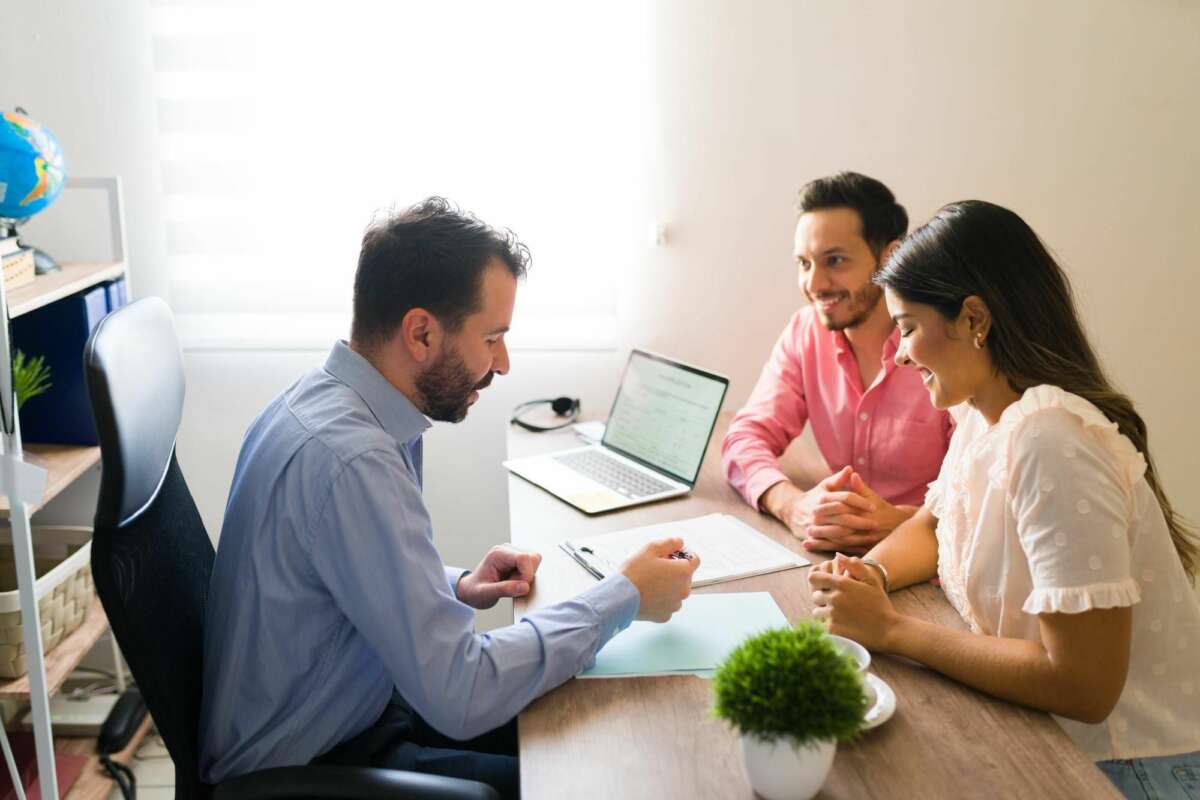 Un trabajador del sector bancario explica a una pareja las condiciones de su hipoteca. Foto: Freepik.