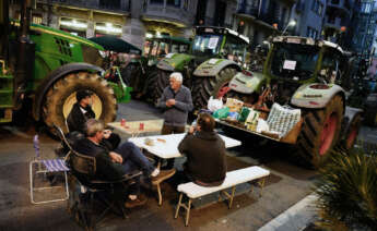 GRAFCAT9485. BARCELONA, 07/02/2024.- Varios agricultores descansan en la calle Argón de Barcelona después de que centenares de tractores hayan tomado el centro de Barcelona durante la marcha agrícola formada por tractores que ha partido de diversos puntos de Cataluña, en una protesta en la que las organizaciones agrarias denuncian el exceso de burocracia, el coste del gasóleo, de los fertilizantes y exigen soluciones urgentes a las administraciones públicas. EFE/Enric Fontcuberta