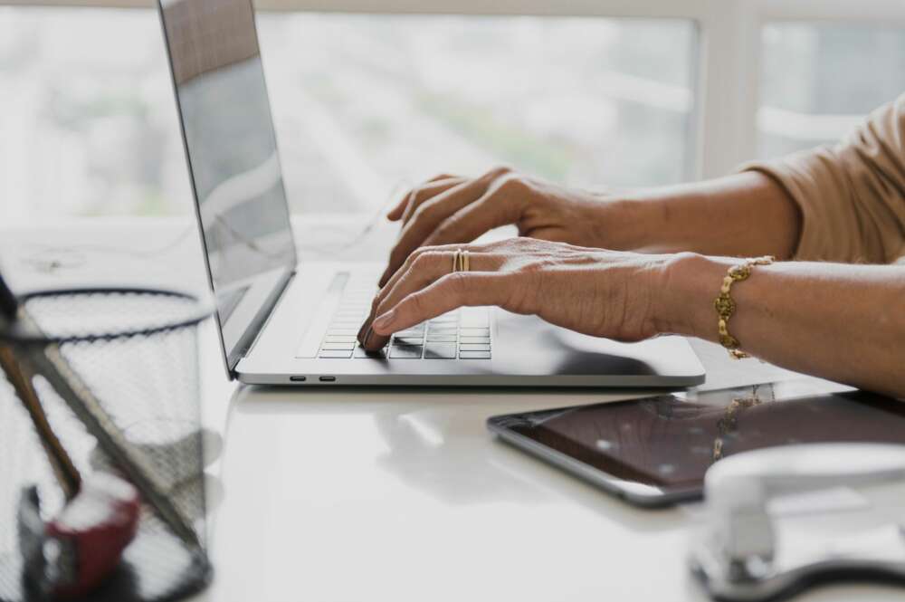 Una mujer utiliza un ordenador en su escritorio. Foto: Freepik.