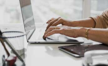 Una mujer utiliza un ordenador en su escritorio. Foto: Freepik.