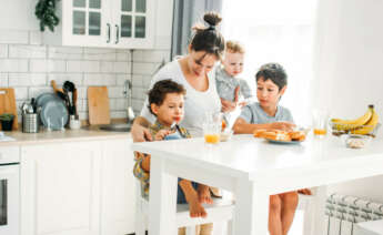 Una madre embarazada con tres hijos más en la cocina