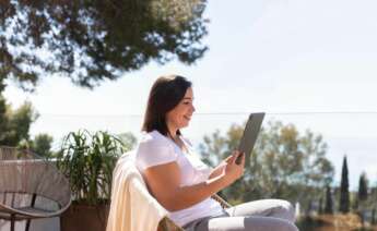 Una mujer utiliza una tablet en una zona rural. Foto: Freepik.