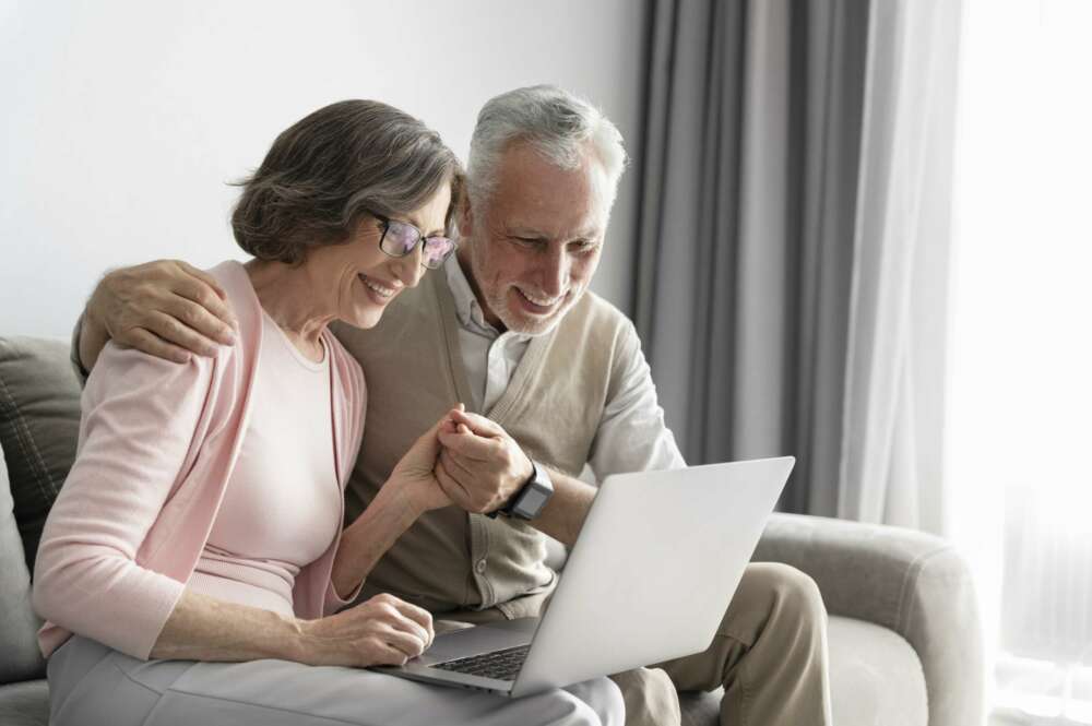dos ancianos sonriendo viendo un ordenador