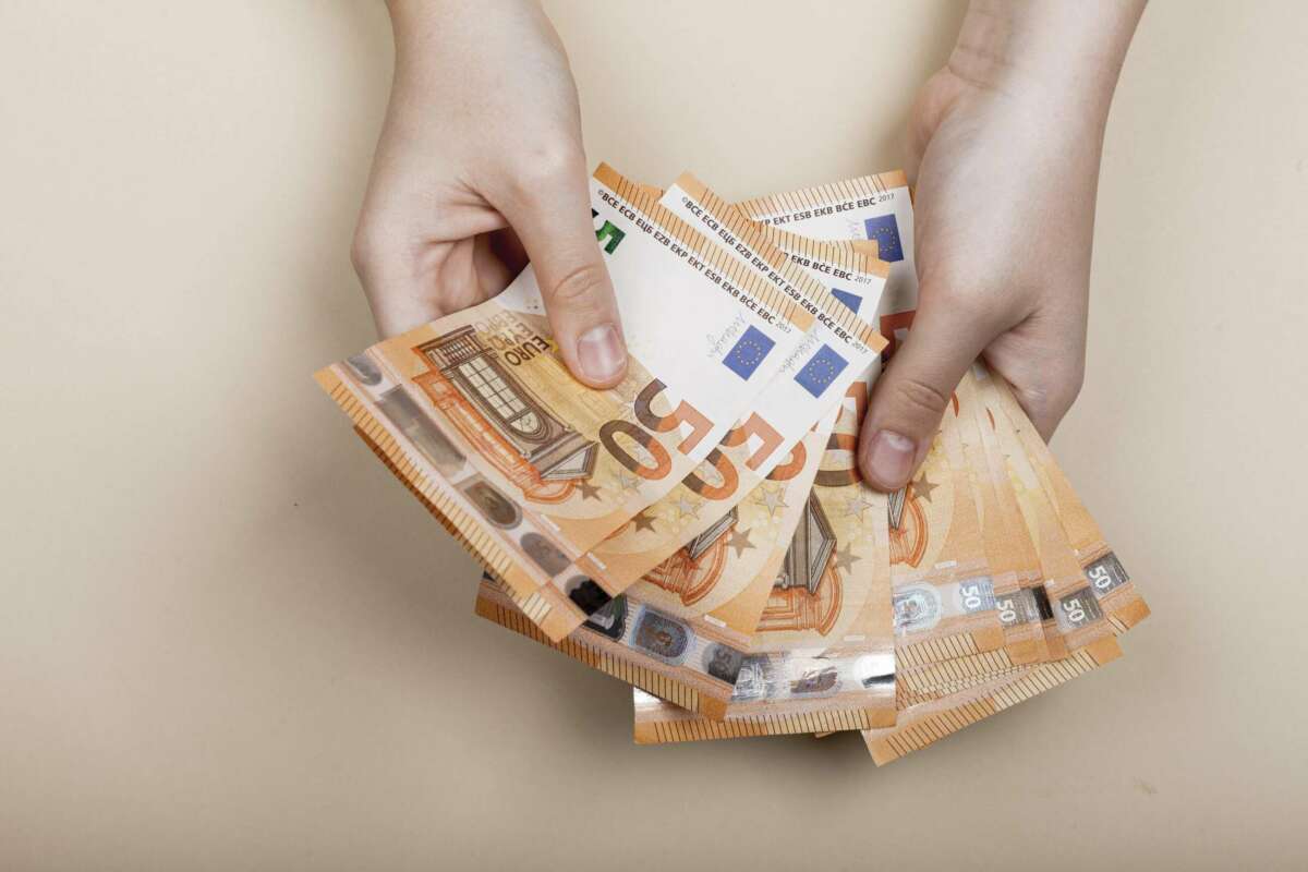 Una persona cuenta varios billetes de 50 euros. moroso. asnef. Foto: Freepik.