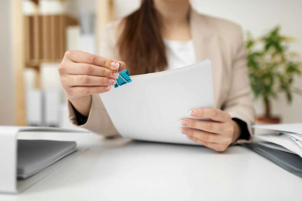 Una persona consulta un documento en una oficina. Foto: Freepik.