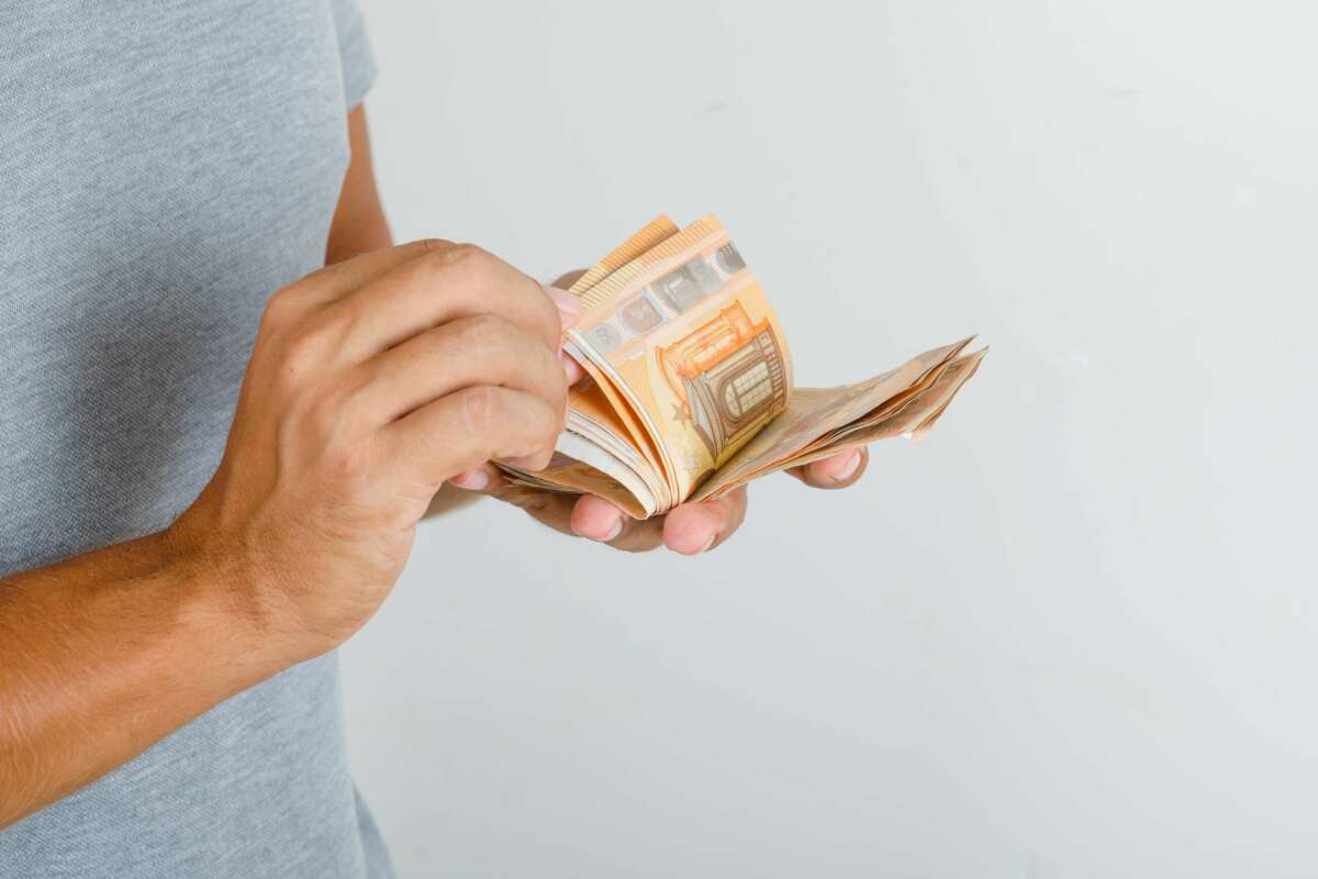 Un hombre cuenta billetes de 50 euros. Préstamo. Foto: Freepik.