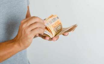 Un hombre cuenta billetes de 50 euros. Préstamo. Foto: Freepik.