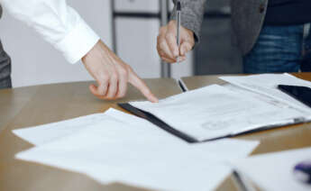 una persona firmando documentos