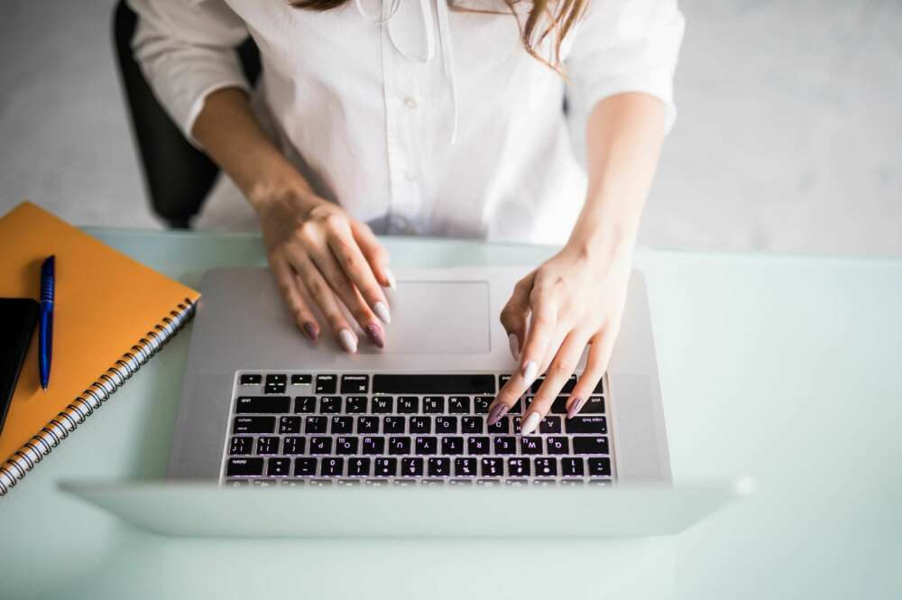 Una mujer realiza un trámite con su ordenador portátil. Foto: Freepik.