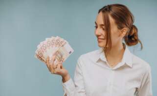 Una mujer mira distintos billetes. Préstamo. Foto: Freepik.