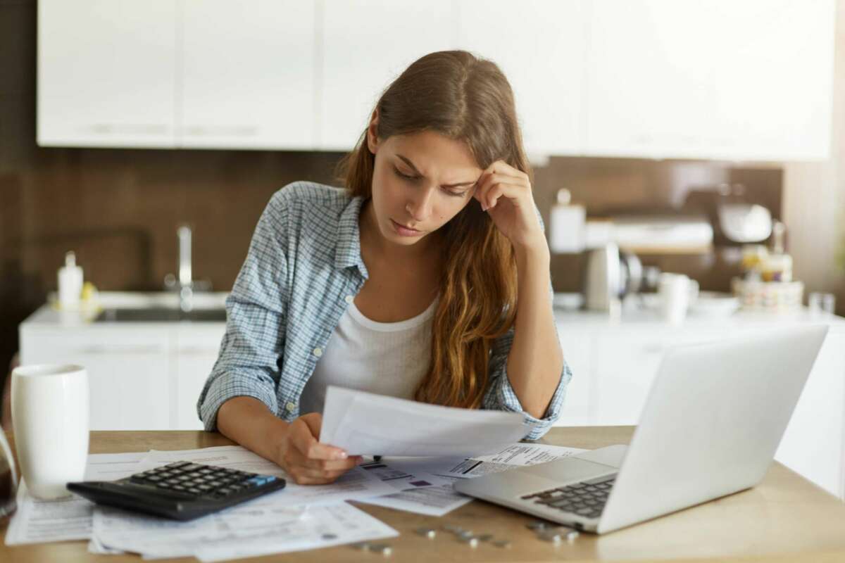 Una mujer consulta un documento. Pago. Foto: Freepik.