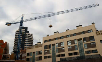 Vivienda de varios pisos al lado de otros edificios en construcción.