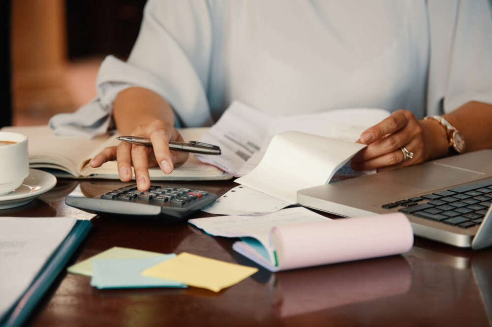 Hombre haciendo cálculos con papeles y boletas