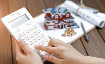 Una mujer utiliza una calculadora antes de solicitar una hipoteca. ICO. Unicaja. Foto: Freepik.