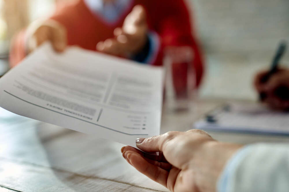 Hombre estirando un papel con la mano en primer plano