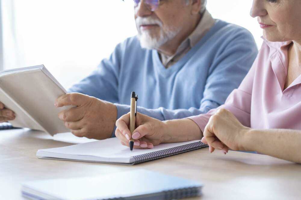 adultos mayores viendo papeles concentrados