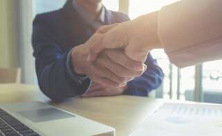 Dos personas de una empresa estrechan sus manos en un acuerdo