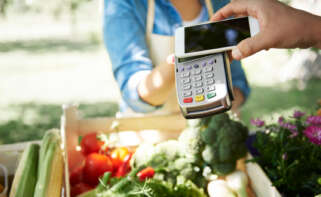 Una compra en un supermercado pagando con un datáfono y un móvil.