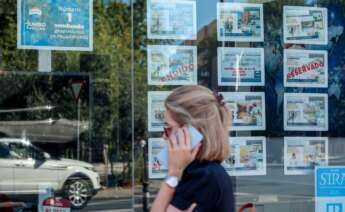 Una mujer camina frente a un escaparate de anuncios de viviendas en Madrid (España). Foto: Ricardo Rubio/Europa Press