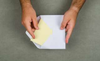 Un hombre abre una carta. Foto: Freepik.