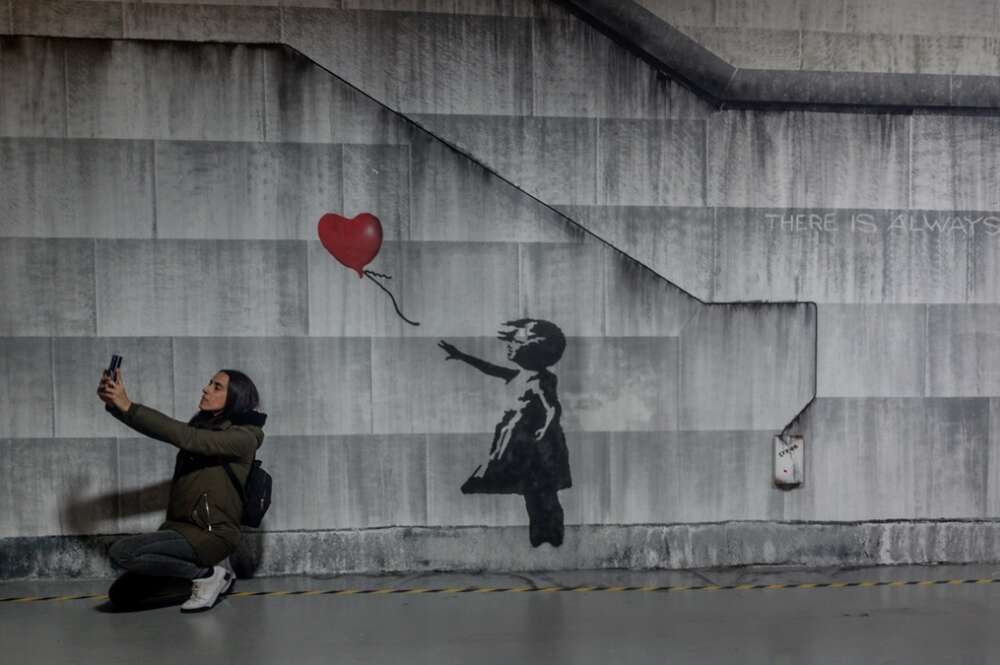 Varias personas recorren la exposición permanente de las obras de Banksy, en el Museo Banksy de Madrid