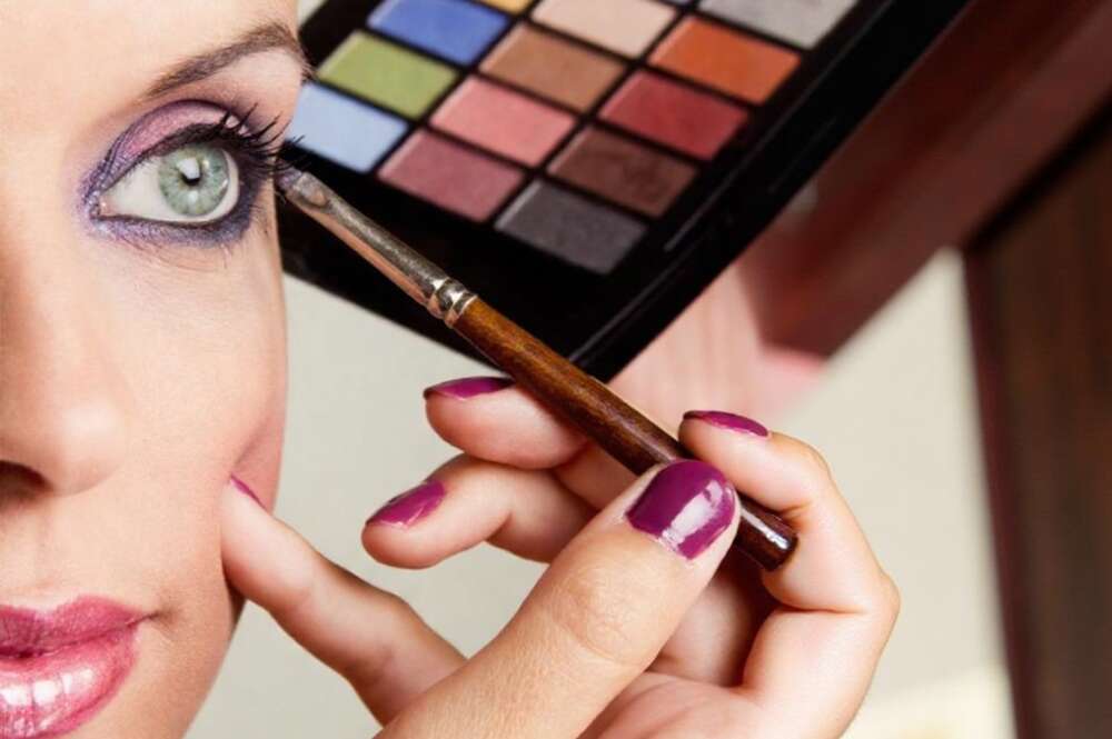Una chica se maquilla con una paleta de sombras de ojos