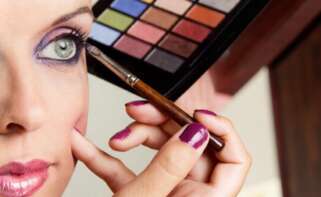 Una chica se maquilla con una paleta de sombras de ojos