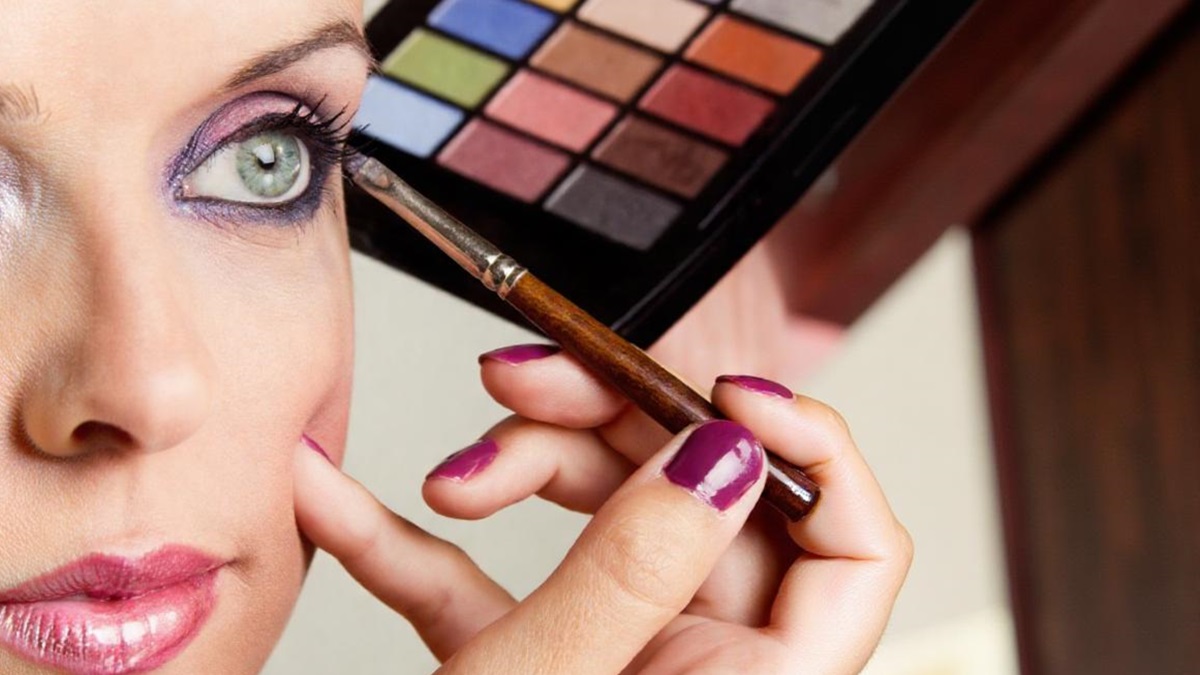 Una chica se maquilla con una paleta de sombras de ojos