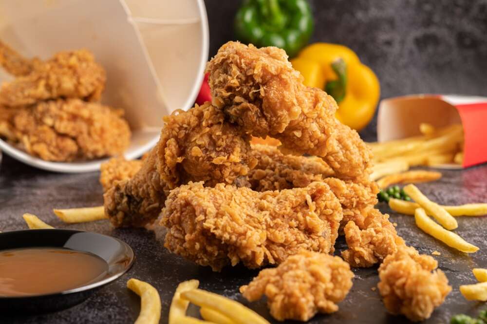 Un cubo de pollo frito con patatas fritas