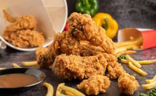 Un cubo de pollo frito con patatas fritas