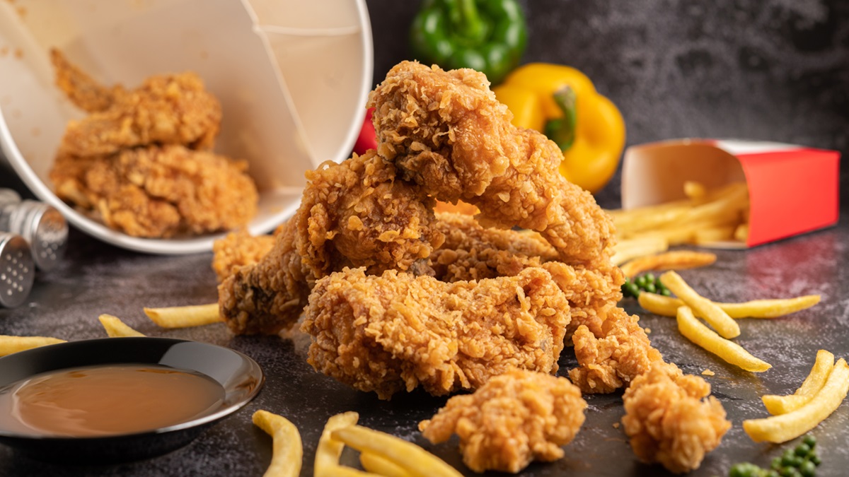 Un cubo de pollo frito con patatas fritas