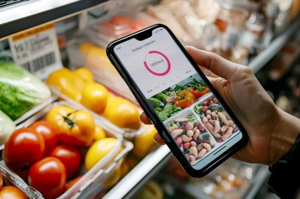 Una persona comprueba las calorías de los alimentos en su móvil