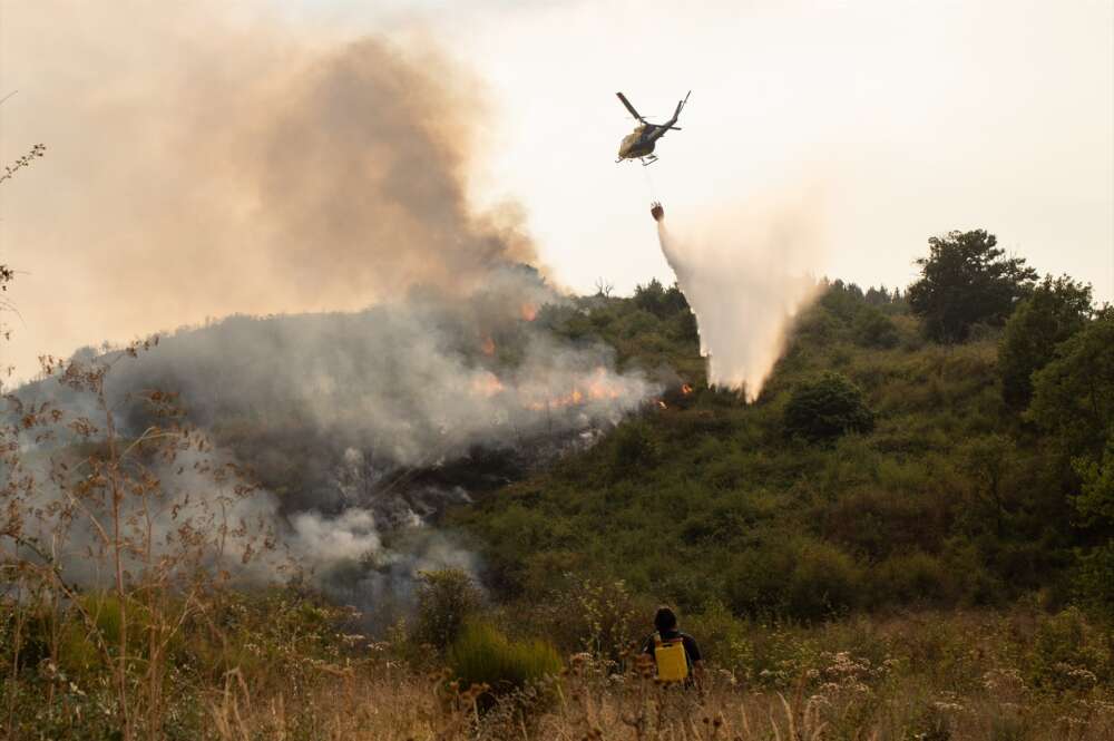 Un helicóptero trabaja en las tareas para la extinción del incendio. Alejandro Martínez Vélez / Europa Press
