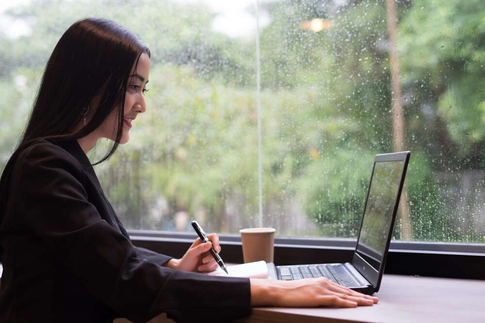 Una mujer teletrabajando por la lluvia