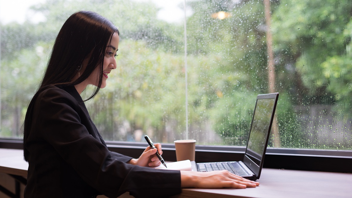 Una mujer teletrabajando por la lluvia
