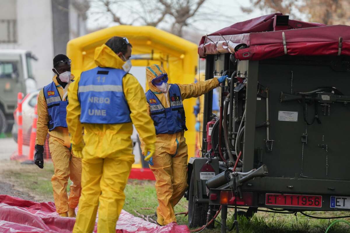 Varias personas de la UME desinfectan vehiculos, durante la presentación de los medios de la UME para el control de la peste porcina en Barcelona.