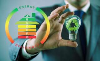 Un hombre sostiene una bombilla en una representación de eficiencia energética | Foto de 123RF/Elnur