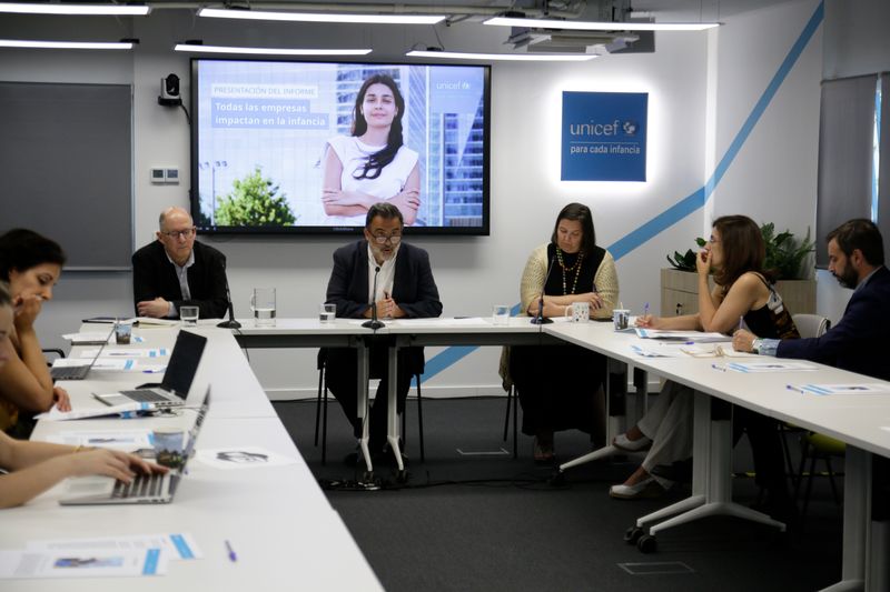 Con camisa gris, bajo la pantalla, a la izquierda, Álvaro Arenas Sarmiento (IE University). Con camisa blanca, bajo la pantalla, a la derecha, José María Vera, director ejecutivo de UNICEF España. Foto: © UNICEF España.
