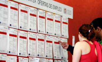 Dos jóvenes leen las ofertas de empleo en un tablón de anuncios