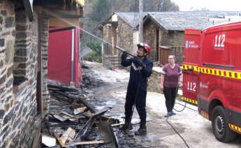 Un bombero enfría una vivienda arrasada por el fuego en Alixo, O Barco de Valdeorras (Ourense). - EUROPA PRESS