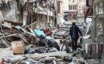 Un niño camina entre edificios derrumbados en la víspera del Ramadán, después de un terremoto en Kahramanmaras, Turquía