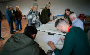 Varias personas ejercen su derecho a voto en la mesa electoral del local parroquial de Recelle