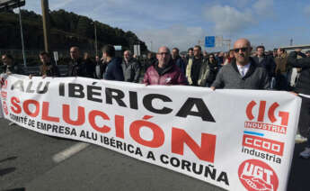 Un grupo de personas protesta con una pancarta durante una concentración frente a la fábrica de Alu Ibérica, a 14 de marzo de 2023, en A Coruña, Galicia