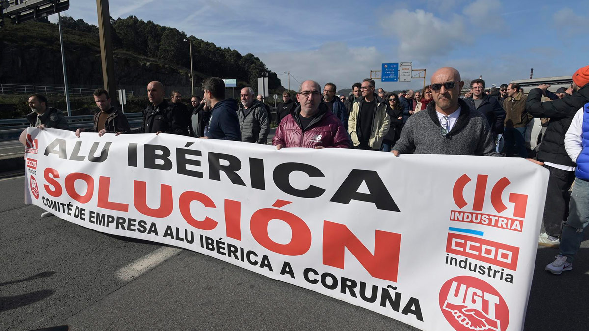 Un grupo de personas protesta con una pancarta durante una concentración frente a la fábrica de Alu Ibérica, a 14 de marzo de 2023, en A Coruña, Galicia