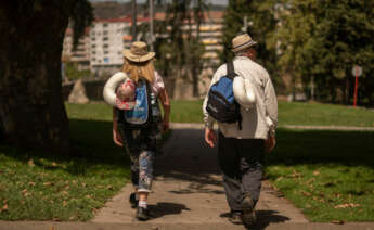 Dos turistas se protegen del intenso sol con sombrero en Ourense durante la cuarta ola de calor