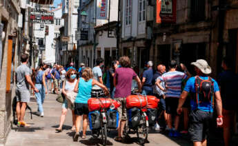 Varios peregrinos caminan por las calles de Santiago